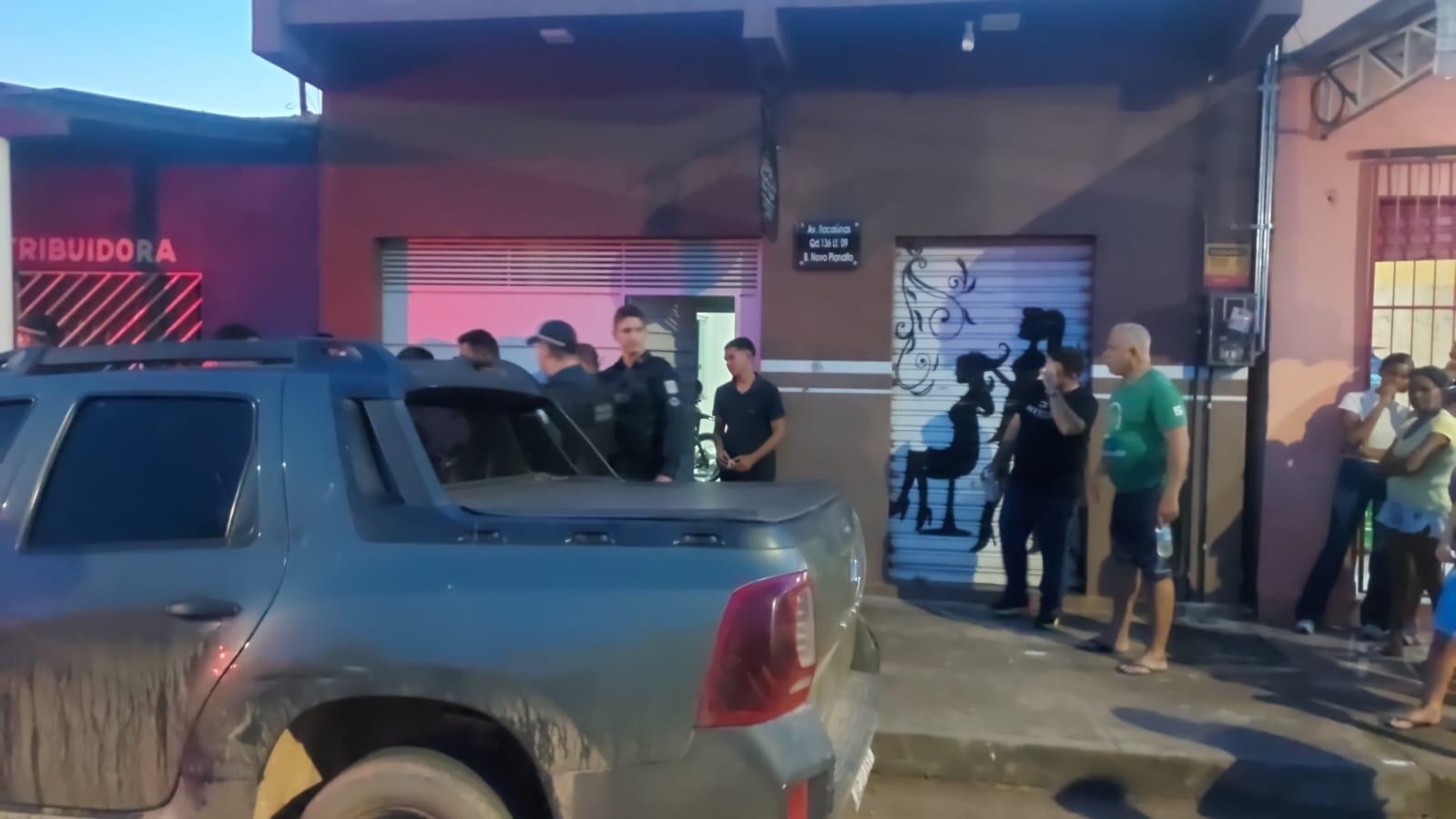 A imagem em destaque mostra policiais militares e moradores próximos ao local onde o crime ocorreu.