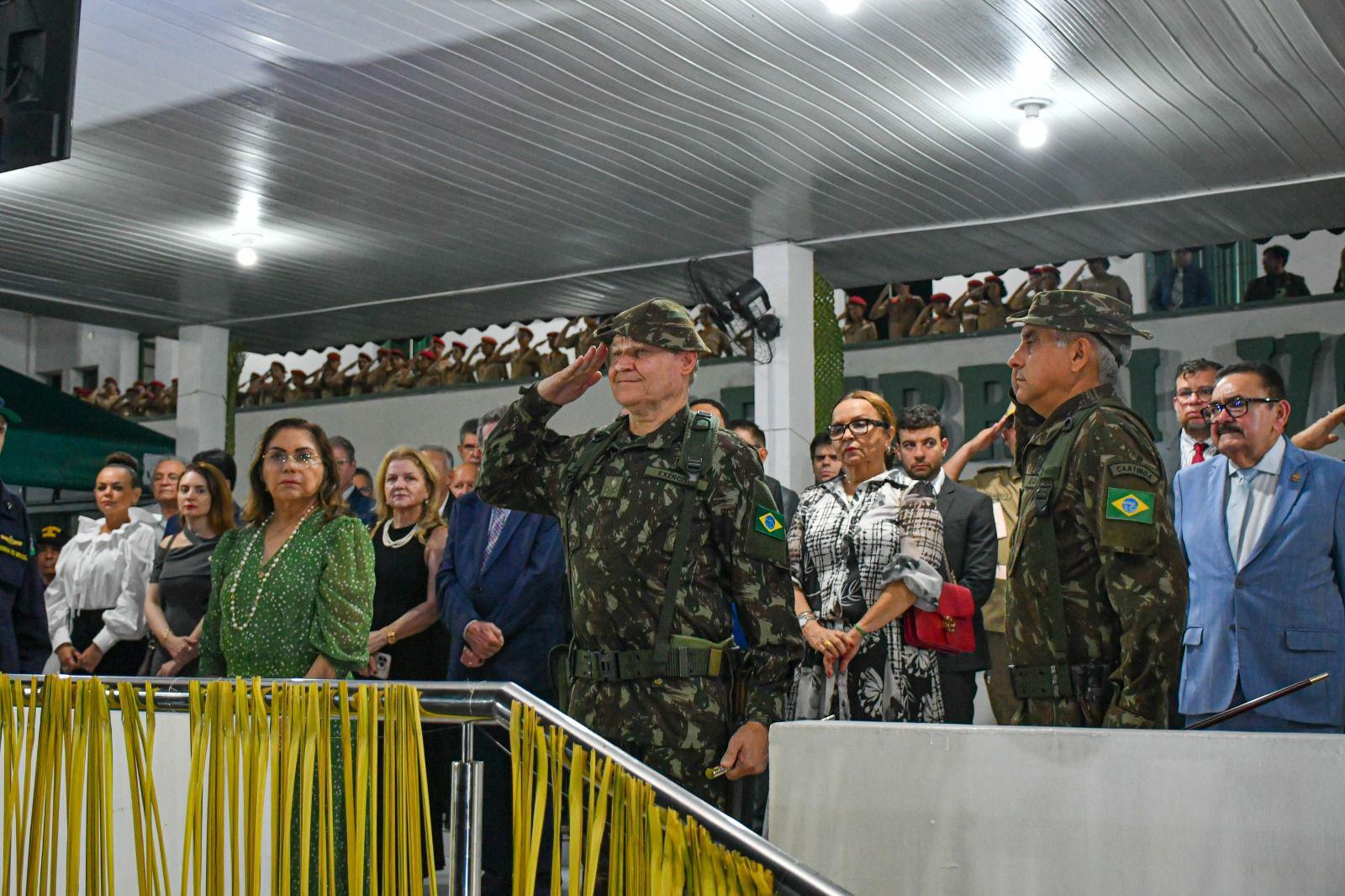 A imagem em destaque mostra militares prestando continência.