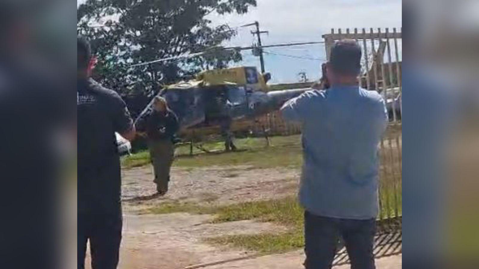 A imagem em destaque mostra o momento em que o homem ferido é levado de helicóptero até a ambulância.