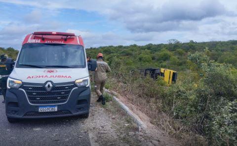 A imagem em destaque mostra uma ambulância no local do acidente e o ônibus tombado ao fundo.